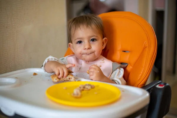 Lindo Bebé Una Silla Bebé Naranja Está Masticando Intensamente Pedazo — Foto de Stock
