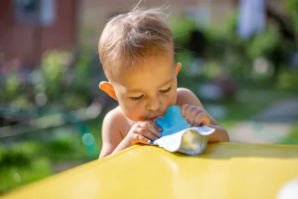 Bebé Comiendo Puré Frutas Bolsa Mirando Comida Delante Mesa Amarilla — Foto de Stock