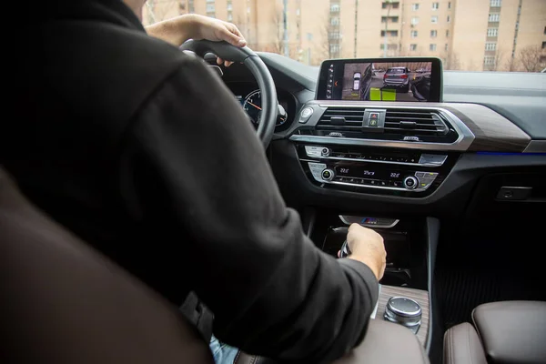 Moskova, Rusya - 7 Kasım 2019: Adam BMW x3 m serisi üzerinde parkong radarlı surround görüş sistemi teknolojisi kullanarak park ediyor. Güvenli sürüş. park desteği.