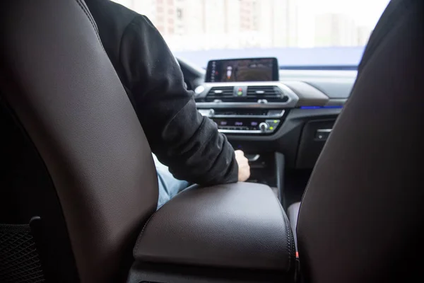 premiium driving. view from the back seat of a modern premium car. the driver sits behind the steering wheel, in front of him the front panel in blur