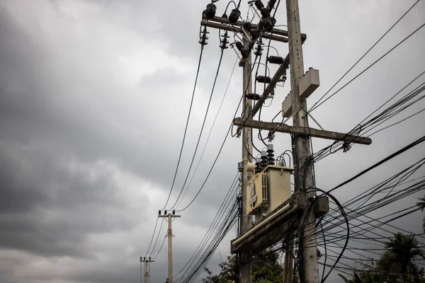 Ledningar fästa vid den elektriska stolpen, kaos av kablar och ledningar på en elektrisk stolpe på asiatisk gata. elbegreppet — Stockfoto