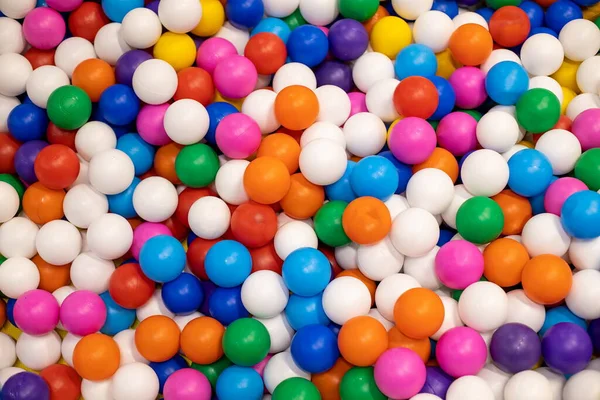 Arka plan için çok renkli plastik topların dokusu. Çocuk odaları, oyun alanları için. Yakın çekim, üst görünüm
