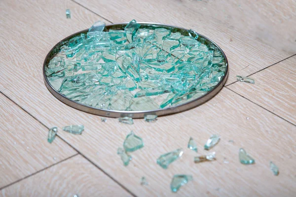 Un primer plano de una tapa de vidrio roto se encuentra en una estaca de baldosas. fragmentos de vidrio brillan. enfoque suave, vista lateral —  Fotos de Stock