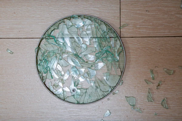 Un primer plano de una tapa de vidrio roto se encuentra en una estaca de baldosas. fragmentos de vidrio brillan. enfoque suave, vista superior —  Fotos de Stock