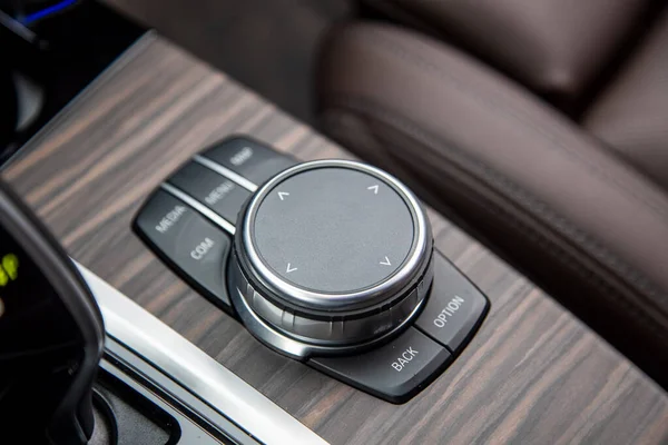 Multimedia system control wheel on a wooden panel in a modern premium luxury exencive new car. close-up, soft focus. — Stock Photo, Image