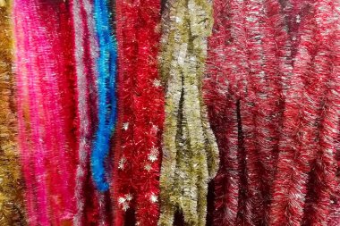 Doku kırmızı, altın sarısı, mavi parlak yeni yıl süsleri dikey yağmur. yakın çekim, yumuşak odak.