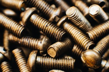 Yakın plan, makro. Eski Sovyet pirinç teneke kafa düz başlı tornavidayla vidalanıyor. Doku, vidaların arka planı. Altın renkli vidalar. Kirli tahta vidaları yağda. Pirinç hurda metal.
