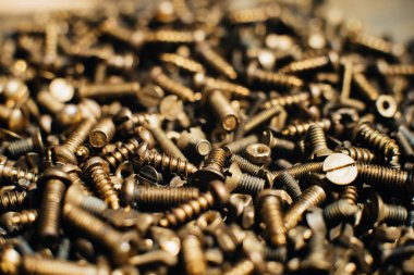 Yakın plan, makro. Eski Sovyet pirinç teneke kafa düz başlı tornavidayla vidalanıyor. Doku, vidaların arka planı. Altın renkli vidalar. Kirli tahta vidaları yağda. Pirinç hurda metal.