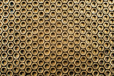 Yakın plan, makro. Yaşlı Sovyet pirinç kaçıkları. Pirinç cevizlerinin dokusu, arkaplanı bal peteği şeklinde dizilmiş. Altın rengi fındıklar. Yağda pişmiş fındık. Pirinç hurda metal.