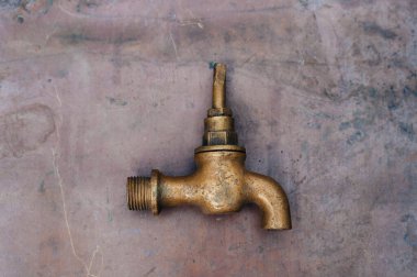 Pirinç hurda metal: musluklar, tişörtler, prizler ve çeşitli tesisat parçaları, yedek parçalar. Bakır bir yaprağın arka planına karşı. Yakın plan..