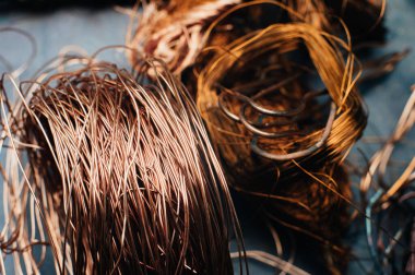 Bakır hurda metal, kablo, motor ve trafolar, yalıtımsız elektrik telleri. Bakır bir yaprağın arka planına karşı. Yakın plan. Makro.