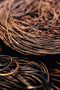 Bakır hurda metal, kablo, motor ve trafolar, yalıtımsız elektrik telleri. Oksitlenmiş bakır kablo. Bakır bir yaprağın arka planına karşı. Yakın plan. Makro.