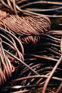 Bakır hurda metal, kablo, motor ve trafolar, yalıtımsız elektrik telleri. Oksitlenmiş bakır kablo. Bakır bir yaprağın arka planına karşı. Yakın plan. Makro.