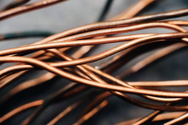 Bakır hurda metal, kablo, motor ve trafolar, yalıtımsız elektrik telleri. Bakır bir yaprağın arka planına karşı. Yakın plan. Makro.