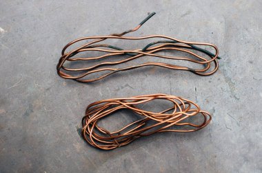 Bakır hurda metal, kablo, motor ve trafolar, yalıtımsız elektrik telleri. Bakır bir yaprağın arka planına karşı. Yakın plan. Makro.