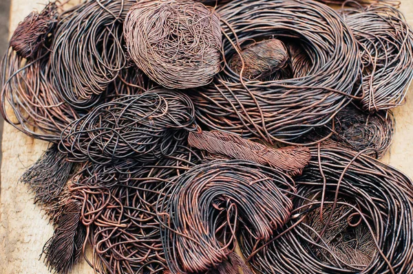 Copper scrap metal, wire, windings of motors and transformers, electrical wire without insulation. Calcined oxidized copper wire. Against the background of a copper sheet. Close-up. Macro.