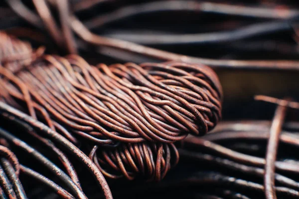 Copper scrap metal, wire, windings of motors and transformers, electrical wire without insulation. Calcined oxidized copper wire. Against the background of a copper sheet. Close-up. Macro.