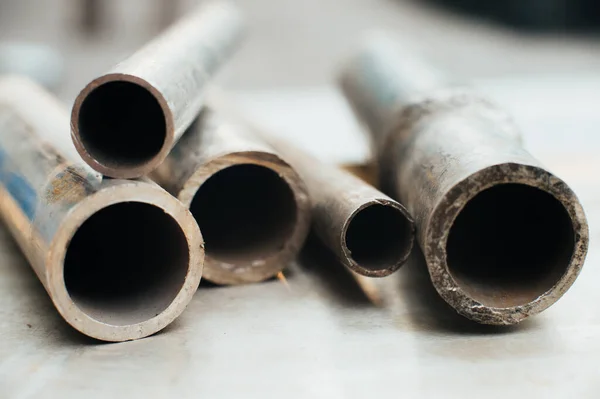 Stainless steel scrap metal, stainless steel pipes on the background of a stainless steel sheet. Close-up. Macro.