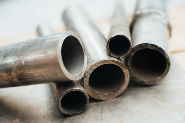 Stainless steel scrap metal, stainless steel pipes on the background of a stainless steel sheet. Close-up. Macro.