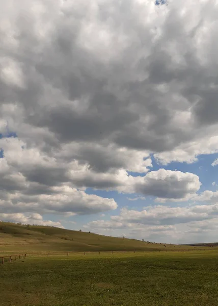 多云的春天的天空笼罩着田野 — 图库照片