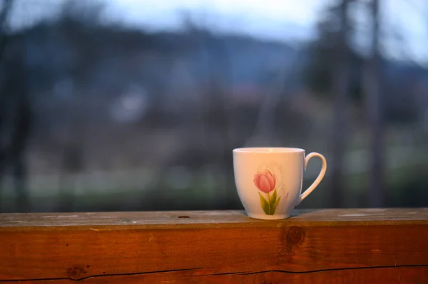 a cup of coffee withe a flower illustration on a blurry background