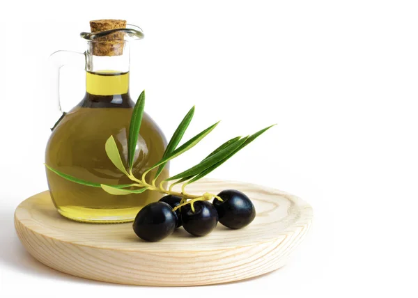 Olivenöl mit Oliven auf einem Holzbrett. — Stockfoto