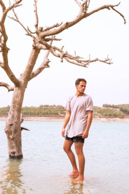  erkek model sular altında gölde bir ölmek üzere olan bir ağacın altında durdu.