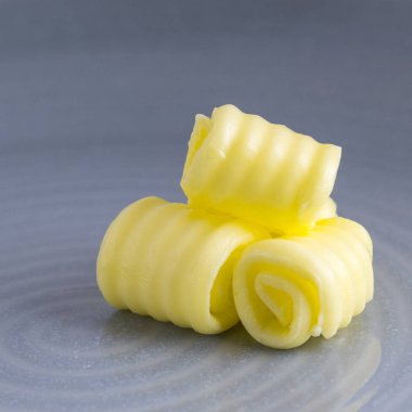 taze organik tereyağı kare görüntü alanı için metin yerleşimi ve mavi bir arka plan bulanık olan bir tabakta kıvrılmış 