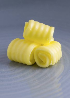 taze organik tereyağı dikey görüntü alanı için metin yerleşimi ve mavi bir arka plan bulanık olan bir tabakta kıvrılmış 