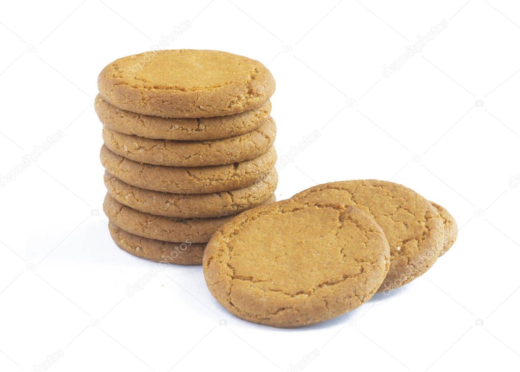 close up plie of ginger biscuits with more behind   isolated on a white background 