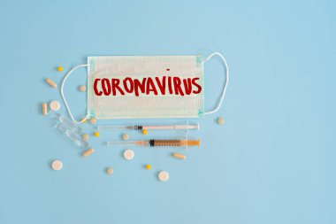 Koronavirüs - 2019 nkov virüsü konsepti, WUHAN. CORONAVIRUS kanında haplar ve şırıngalar bulunan cerrahi maske koruyucu. Çin Coronavirüs salgını. Salgın.