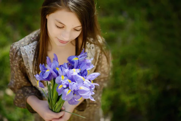 Красива Дівчина Дивиться Букет Весняних Квітів Ірисів Тлі Яскраво Зеленої — стокове фото