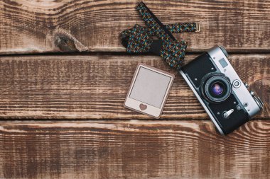 Hippi tarzı. Ahşap bir arka planda kamera ve papyon. Turizm seyahati kavramı. Düz yatıyordu. Boşluğu kopyala.