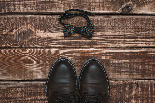 мужские аксессуары галстук-бабочка и кожаные туфли на деревянном фоне. Принято. Плоский лежал
.