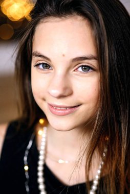 Yeni yıl ağacının yanında güzel bir kız neşeyle gülümsüyor. Yakın plan portre. Mutlu Noeller ve tatiller. Yumuşak seçici odak.