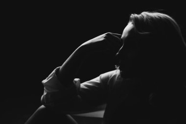 Saklambaç oynayan güzel sarışın bir kızın silueti. Siyah beyaz resim. Yumuşak seçici odak.