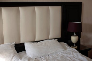 Yatak odasının içi klasik bir şekilde. Komodinli yatak ve lamba. Otel odası..