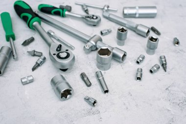 Araba bakım ve onarım konsepti. Gri endüstriyel arka planda paslanmaz krom çelikten yapılmış bir alet. Tornavida, anahtar, anahtar. Uzayı kopyala Düz yatıyordu.