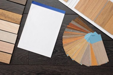 Ev tasarımı konsepti. Müşteriler için doğal ahşap malzeme numunesi. Laminat ve vinil döşeme paleti ve çizimler için boş defter. İnşaat ve onarım.