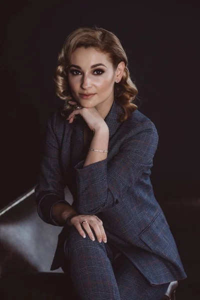 Esmer arka planda takım elbiseli, kendine güvenen güzel bir iş kadınının portresi. Cinsiyet eşitliği kavramı. Güçlü, bağımsız bir kadın. Yumuşak seçici odak
