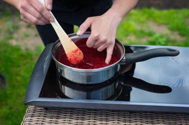 Şef marmelat yapmak için böğürtlen püresi pişiriyor. Çilek reçeli yapma süreci.