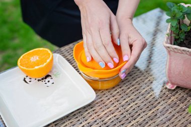 Kadın bir şefin elleri evin önünde taze portakal suyu pişirir..