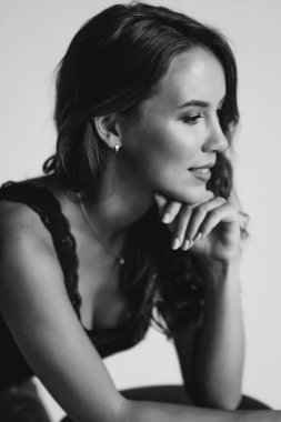 Yakından bakınca, kahverengi gözlü esmer bir kadının portresi 32 yaşında, siyah önlüklü, beyaz arka planda güzel, sağlıklı saçlı bir kadın. Yumuşak seçici odaklanma. Siyah beyaz sanat fotoğrafçılığı.