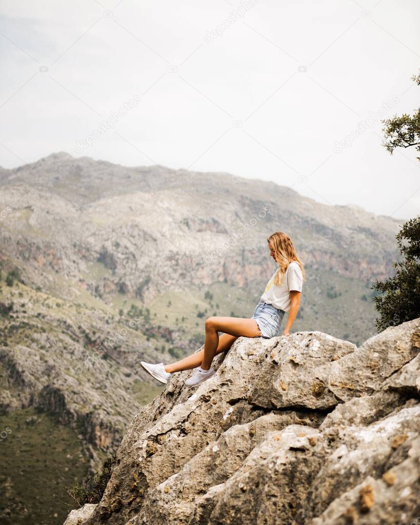 Waiting for adventure. Girl sitting on a rock, Mallorca