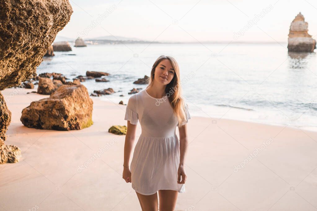 Girl in dress on sandy beach, Praia de Camilo, Portugal