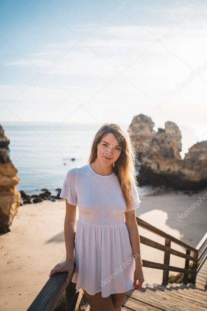 Girl in dress on sandy beach, Praia de Camilo, Portugal