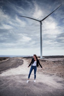 Rüzgar türbinine giden terk edilmiş bir yolda bir kız, Tenerife