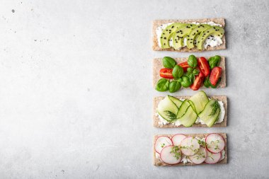 Hafif arka planda farklı türde vejetaryen sandviçler. Üst görünüm, metin için yer.