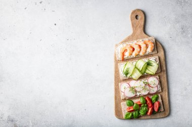 Hafif arka planda farklı sandviçler. Üst görünüm, metin için yer.