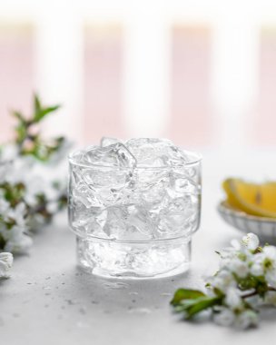 Aydınlık zemin üzerinde bir bardakta buz